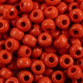 Close-up of 9mm glass crow beads in opaque poppy red, filling the frame