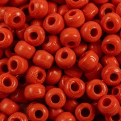 Close-up of 9mm glass crow beads in opaque poppy red, filling the frame