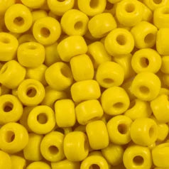 Close-up of 9mm glass crow beads in opaque yellow, filling the frame