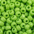 Close-up of 9mm glass crow beads in opaque lime, filling the frame