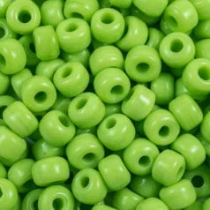 Close-up of 9mm glass crow beads in opaque lime, filling the frame