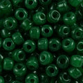 Close-up of 9mm glass crow beads in opaque forest green, filling the frame