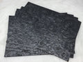 Stack of #49 black faux leather sheets embossed with a tooled floral scroll pattern