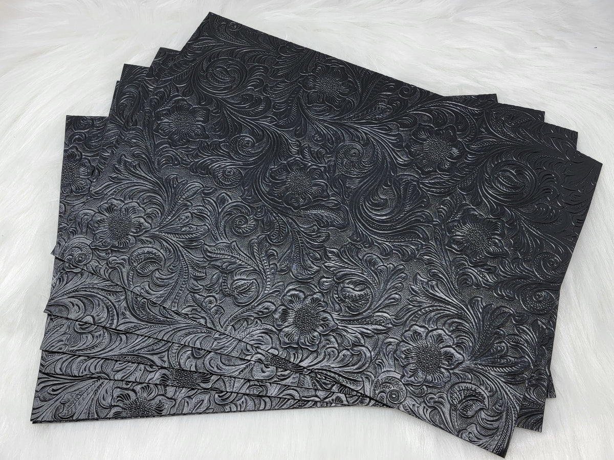 Stack of #49 black faux leather sheets embossed with a tooled floral scroll pattern