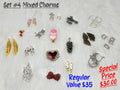 Set #4 of mixed charms on white fur, including gold feathers, a pinecone, ice cream heart, red heart and red bow
