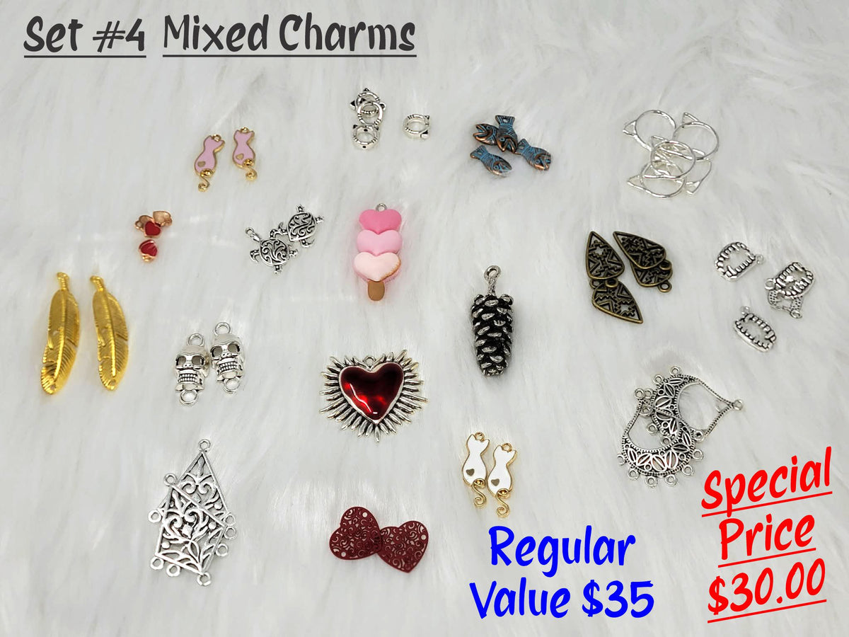 Set #4 of mixed charms on white fur, including gold feathers, a pinecone, ice cream heart, red heart and red bow