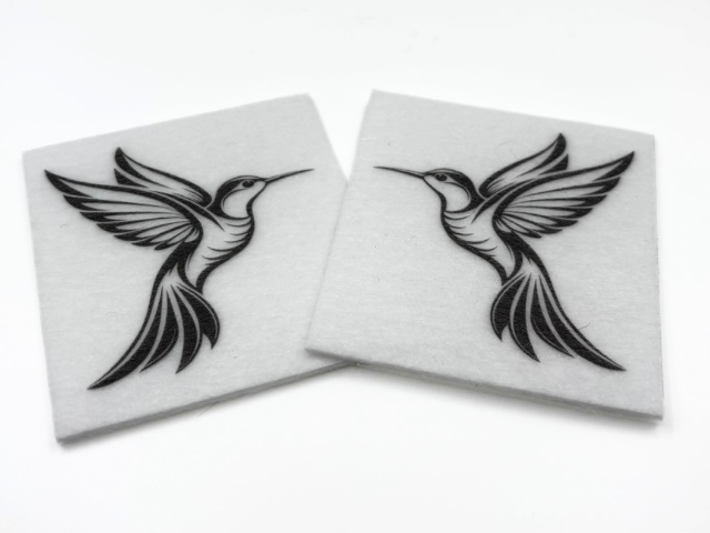 Two beading patterns printed in black on stiff white pellon squares, showing a hummingbird
