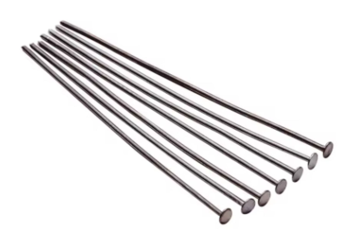 Fan of 50mm gunmetal 20 gauge flat head pins, each with a flat disc head at one end, on white