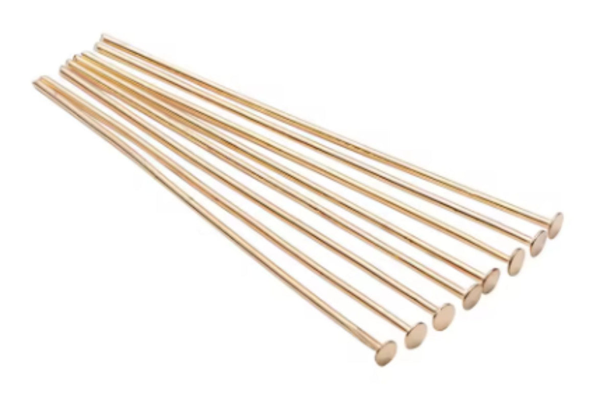 Fan of 50mm KC gold 20 gauge flat head pins, each with a flat disc head at one end, on white