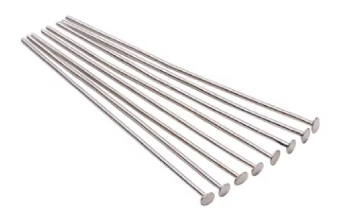 Fan of 50mm rhodium 20 gauge flat head pins, each with a flat disc head at one end, on white