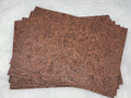 Stack of #55 brown faux leather sheets embossed with a tooled floral scroll pattern