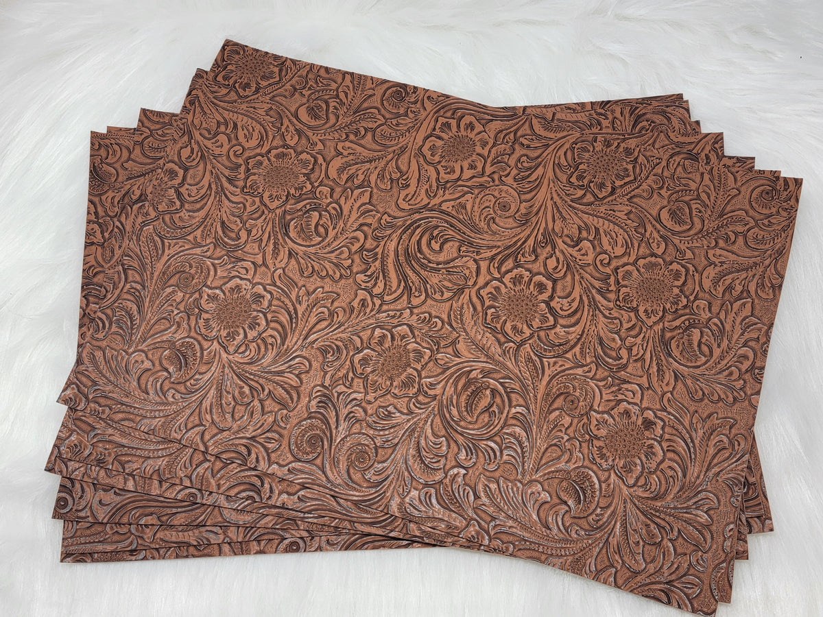 Stack of #55 brown faux leather sheets embossed with a tooled floral scroll pattern