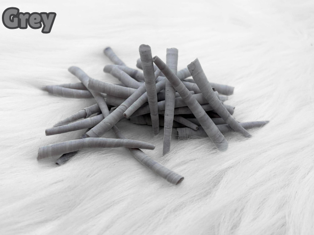 Pile of grey dyed smooth dentalium shells, about 1.5 to 2 inches long, on white faux fur