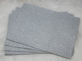 Stack of #58 silver faux leather sheets embossed with a tooled floral scroll pattern