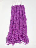 Five hanks of Preciosa 11/0 transparent neon purple seed beads laid out on a white background