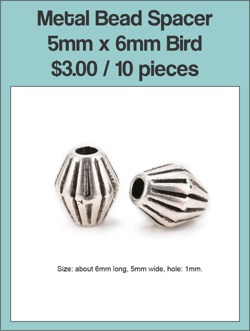 Two silver-tone 5 x 6mm ribbed barrel spacer beads on a labelled product card