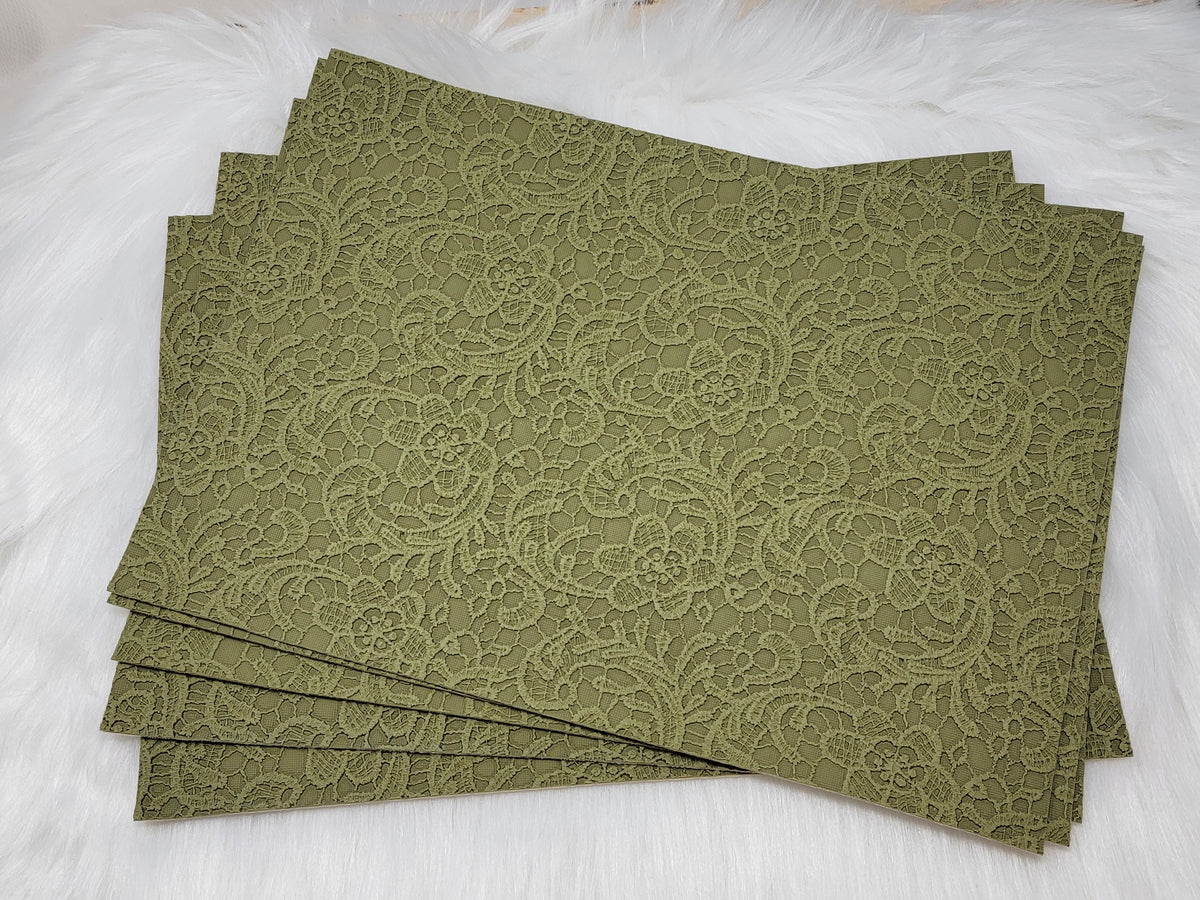Stack of #60 sage faux leather sheets embossed with a tooled floral scroll pattern