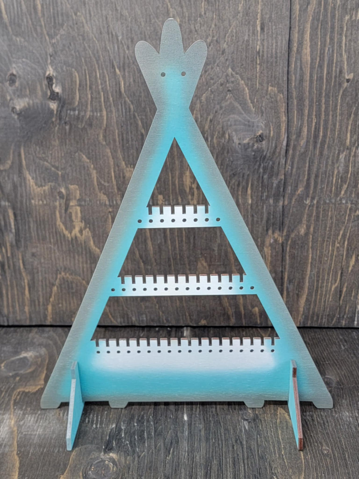 Tipi-shaped earring display rack with rows of holes, in white, turquoise and grey