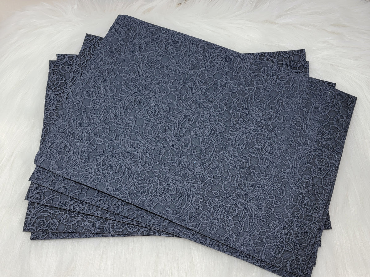 Stack of #61 denim faux leather sheets embossed with a tooled floral scroll pattern