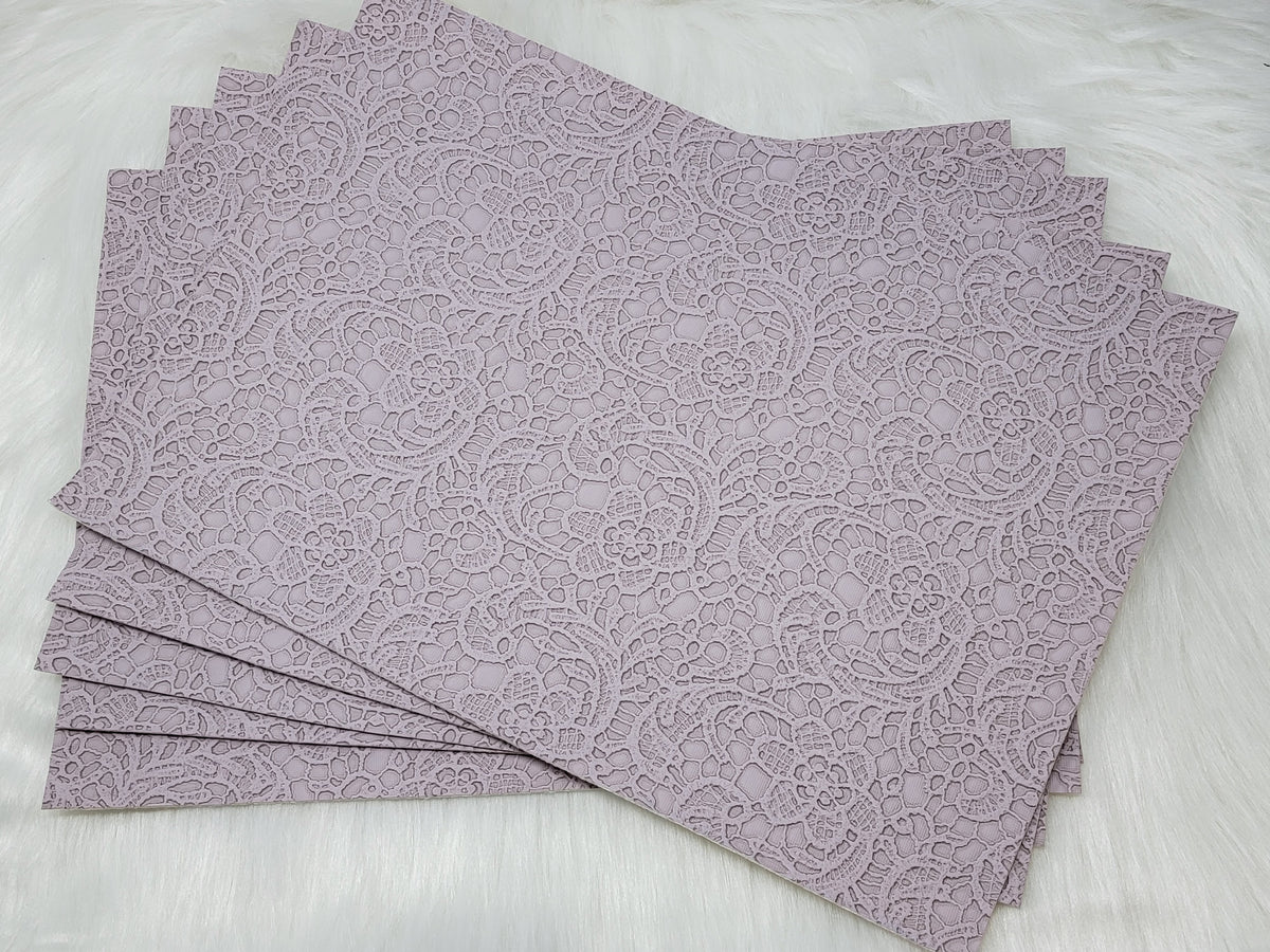 Stack of #62 lilac faux leather sheets embossed with a tooled floral scroll pattern