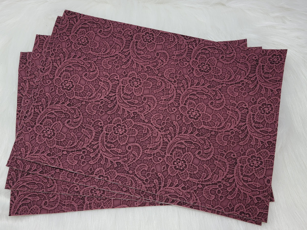 Stack of #63 plum faux leather sheets embossed with a tooled floral scroll pattern