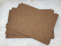 Stack of #64 brown faux leather sheets embossed with a tooled floral scroll pattern