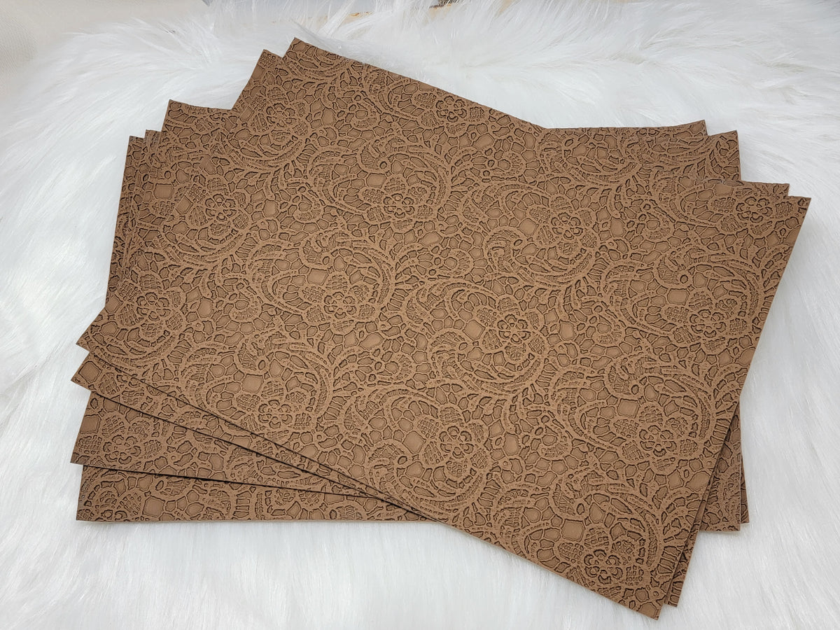Stack of #64 brown faux leather sheets embossed with a tooled floral scroll pattern