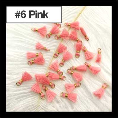 Scattered 1cm pink cotton tassels with gold-tone rings on white fur, labelled #6