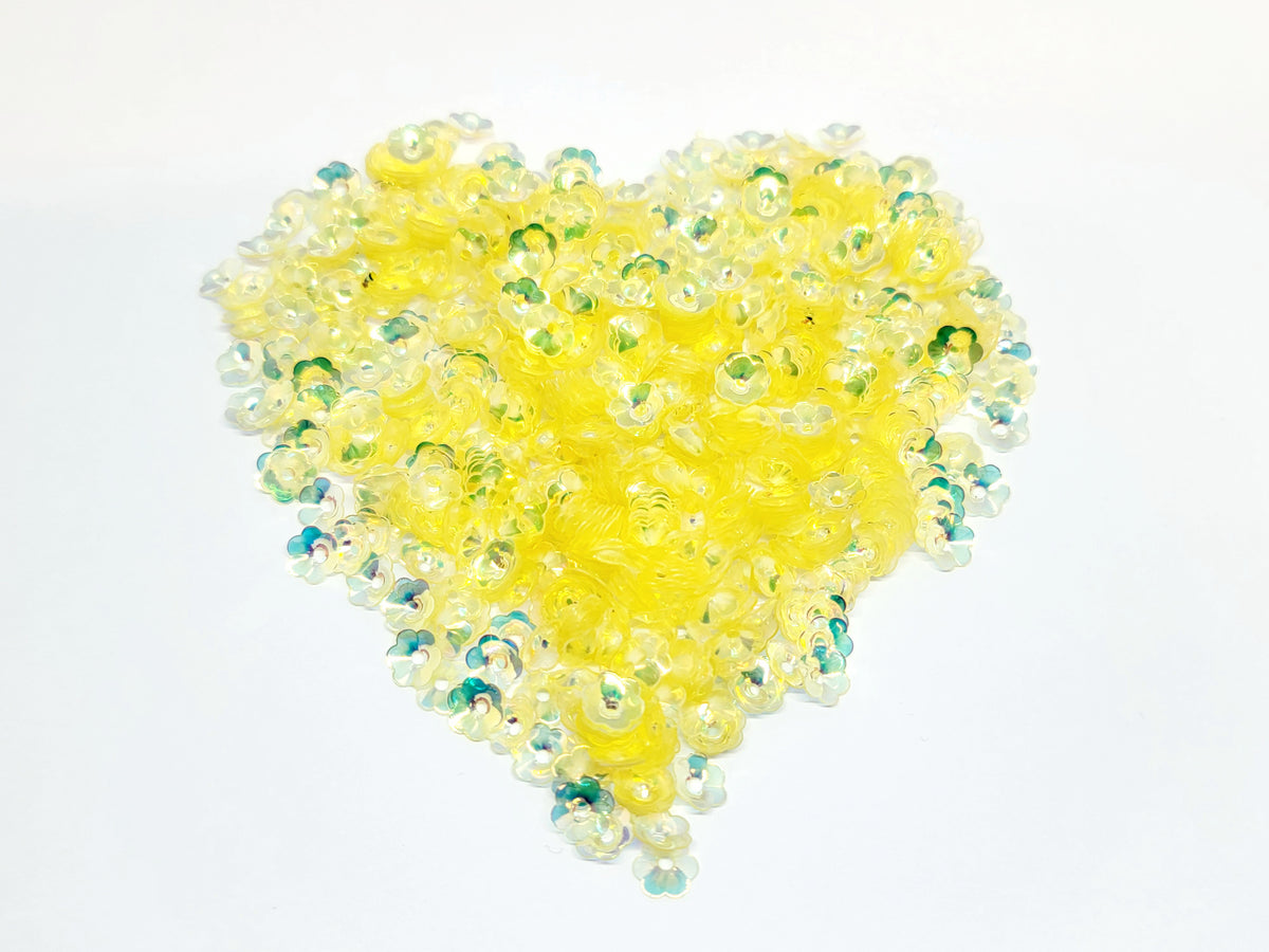 Heart-shaped pile of 6mm iridescent flower sequins in yellow