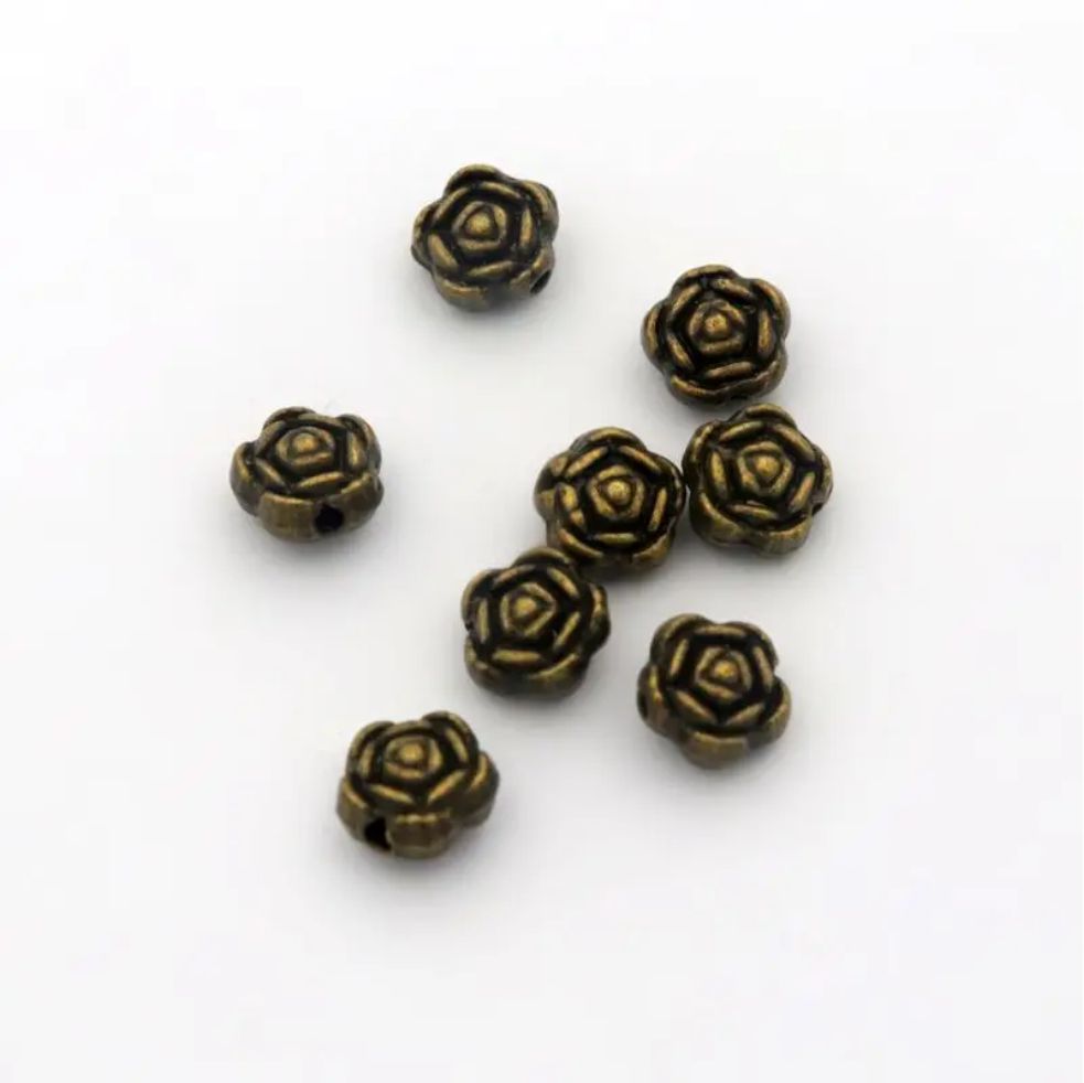 Five bronze-tone 6mm rose spacer beads on a white background