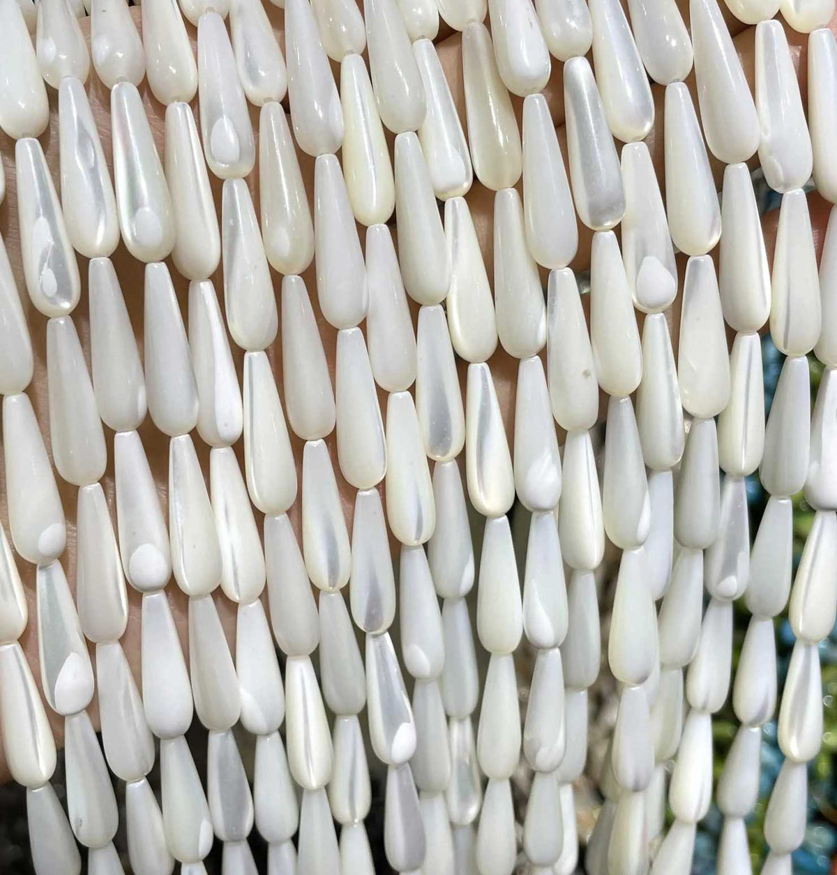 Rows of long white 6 x 20mm mother of pearl drop bead strands