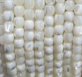 Rows of white 6mm mother of pearl cube bead strands, laid side by side