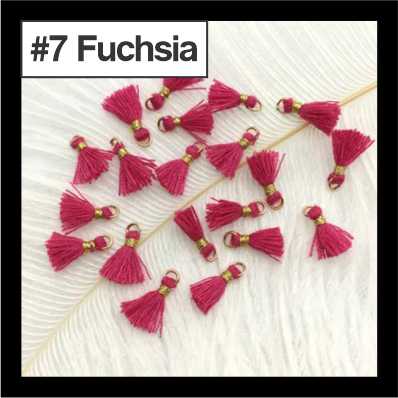 Scattered 1cm fuchsia cotton tassels with gold-tone rings on white fur, labelled #7
