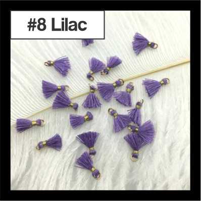 Scattered 1cm lilac cotton tassels with gold-tone rings on white fur, labelled #8