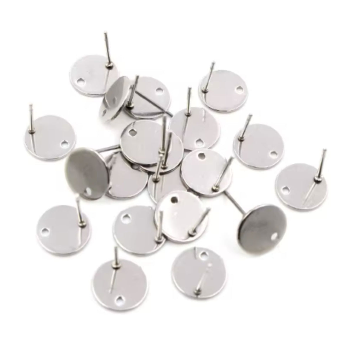 Flat round 8mm stainless steel earring posts with a connector hole, scattered with their backs