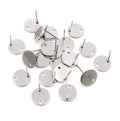 Flat round 10mm stainless steel earring posts with a connector hole, scattered with their backs
