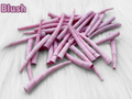 Pile of blush dyed smooth dentalium shells, about 1.5 to 2 inches long, on white faux fur