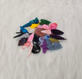 Pile of about 25 random pairs of acrylic cabochons (cabs) in glitter, marbled and solid colours