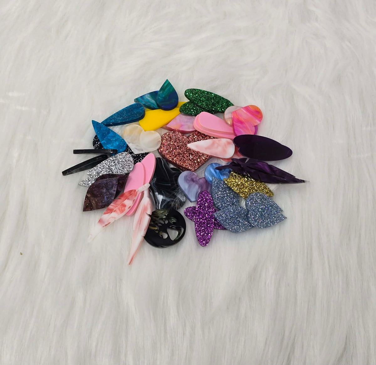 Pile of about 25 random pairs of acrylic cabochons (cabs) in glitter, marbled and solid colours