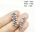 Two silver-tone 9.5 x 26mm flower 3-hole spacers held in fingers, with a size chart