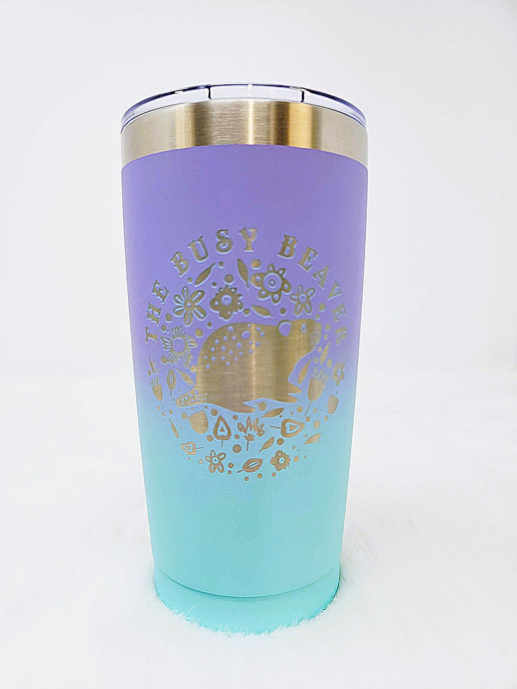 Lilac-to-aqua fade stainless steel tumbler engraved with a round floral beaver logo
