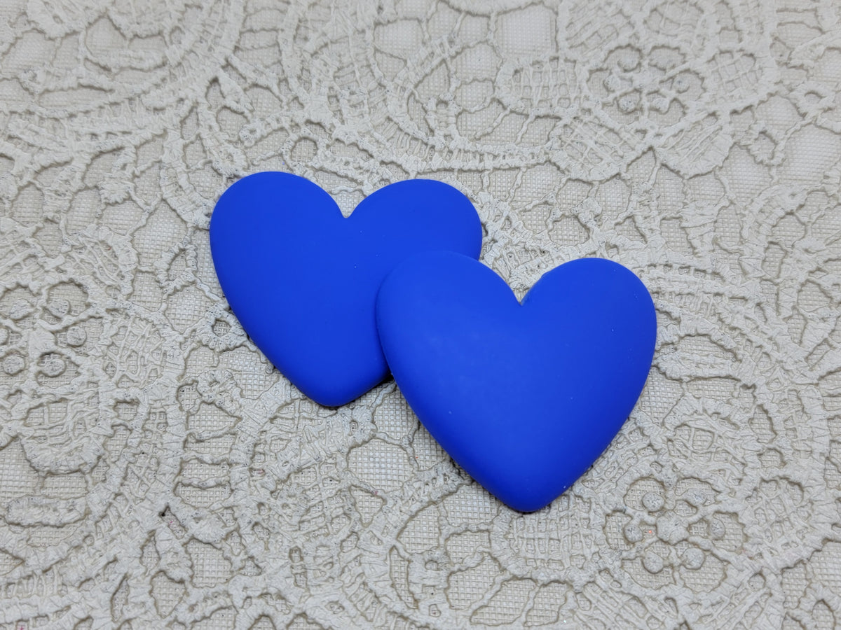 Pair of 37mm matte resin heart cabochons (cabs) in #9 Blue on a grey textured cloth