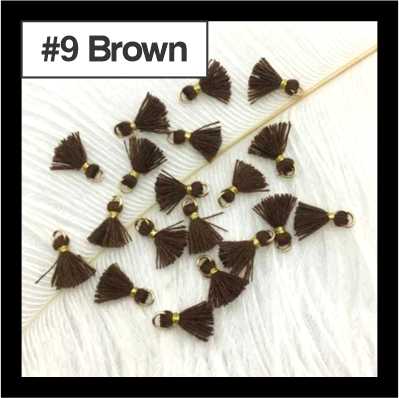 Scattered 1cm brown cotton tassels with gold-tone rings on white fur, labelled #9