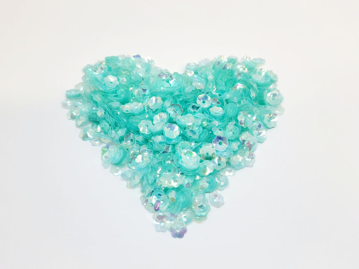 Heart-shaped pile of 6mm iridescent flower sequins in seafoam
