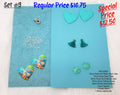 Set #9: turquoise and floral resin hearts, round cabs, ear wires, teal tassels and a spacer on blue sheets