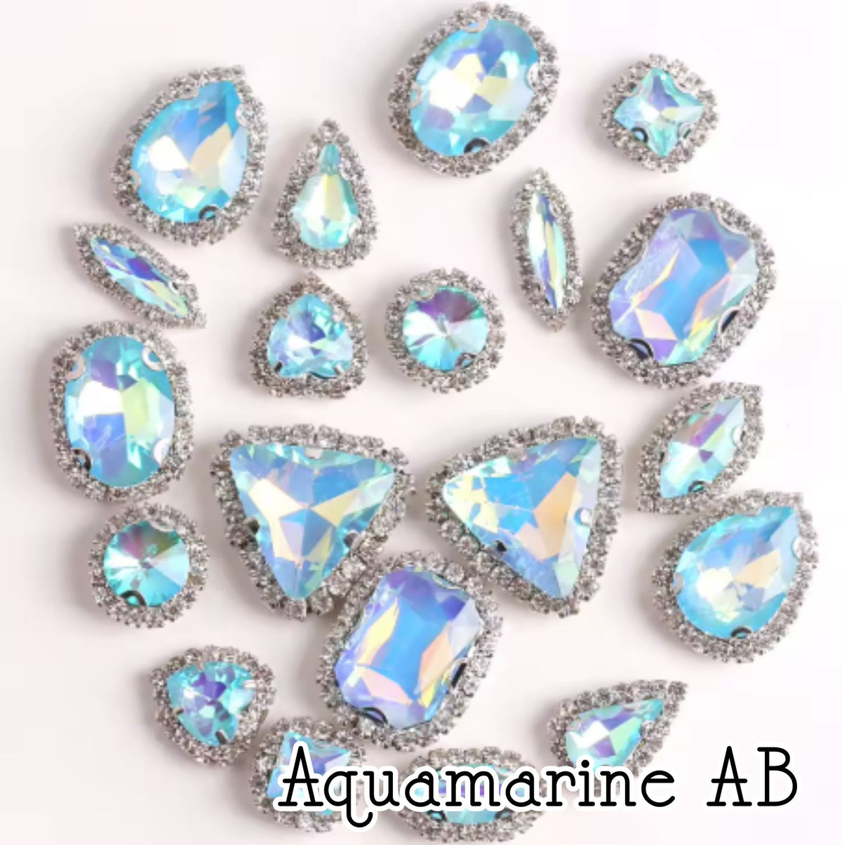 Sew-on crystal rhinestones in aquamarine AB, in 10 shapes with silver claw settings