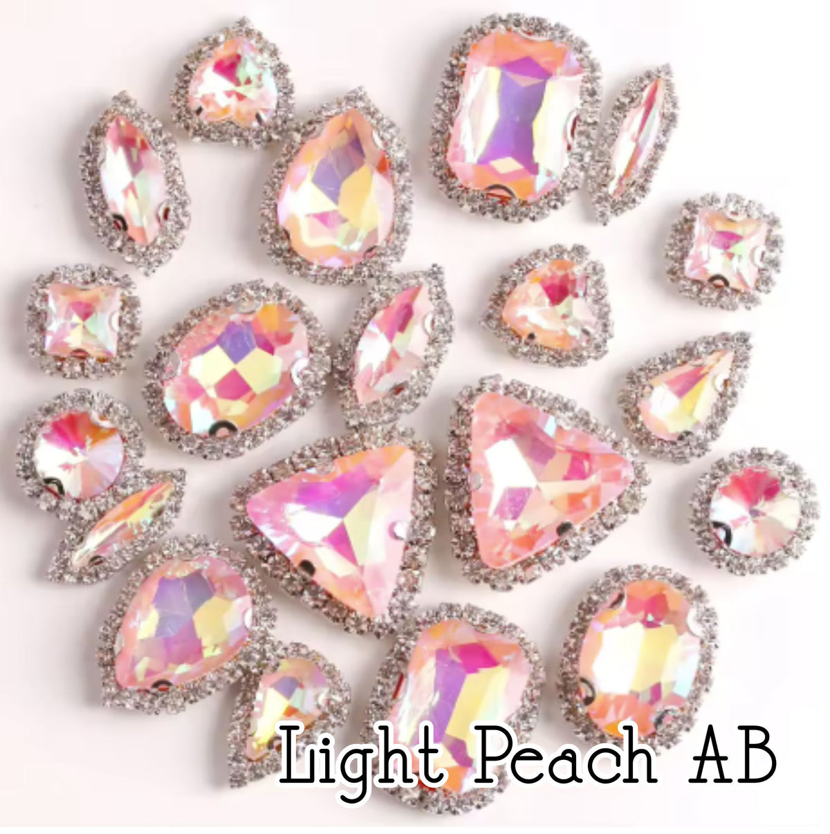Sew-on crystal rhinestones in light peach AB, in 10 shapes with silver claw settings