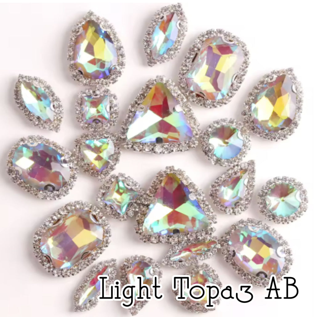 Sew-on crystal rhinestones in light topaz AB, in 10 shapes with silver claw settings