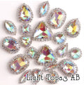 Sew-on crystal rhinestones in light topaz AB, in 10 shapes with silver claw settings