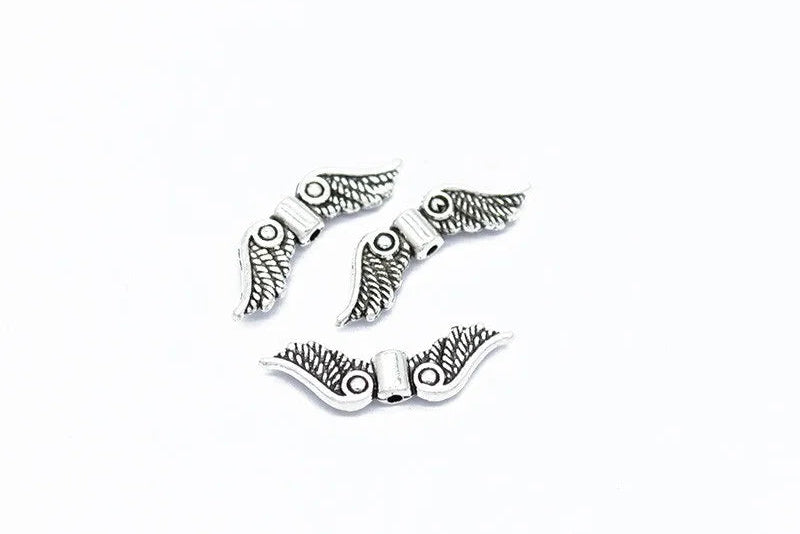 Antique silver 7 x 24mm angel wing spacer bead on a white background